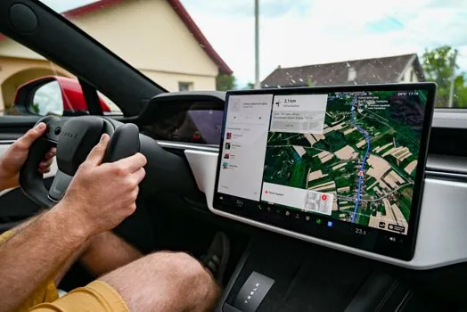 close-up of an electric vehicle center touchscreen showing a generic monthly driver assistance subscription menu, hand nearby but not touching, realistic automotive editorial photo, no logo, no readable text