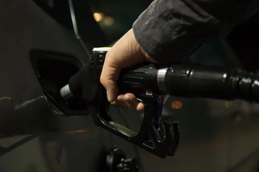 Korean driver comparing gasoline and diesel fuel receipts on car dashboard, calculator and notebook, realistic editorial photo, no text