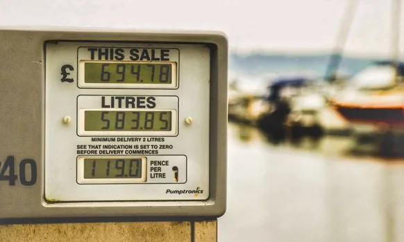 Korean gas station fuel pump and price board, driver holding calculator app, realistic editorial automotive photography, no text