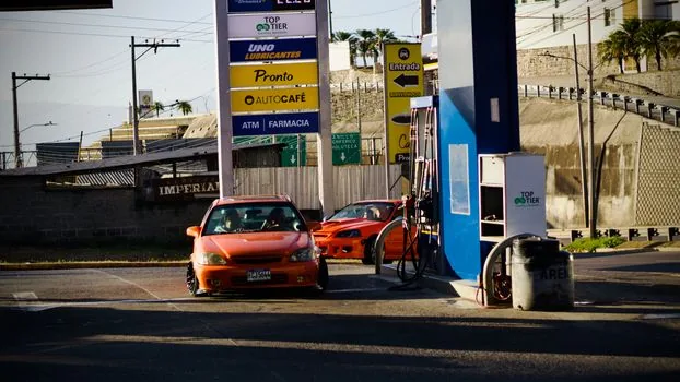 Korean highway commuter car at gas station exit, morning traffic and fuel economy concern, realistic automotive editorial photography, no text