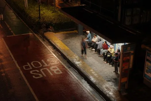 Seoul hospital shuttle bus stop with patient family checking timetable, realistic daytime editorial photo