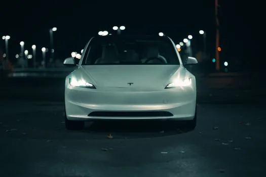 two modern electric sedans parked side by side with subtle factory origin comparison concept, clean daylight, realistic automotive editorial photography, no brand logo, no text