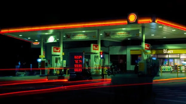Korean family car at highway rest area gas station, driver checking fuel gauge and price board before Chuseok trip, bright realistic photo | 추석 장거리 출발 전 고속도로 주유 계획을 확인하는 장면